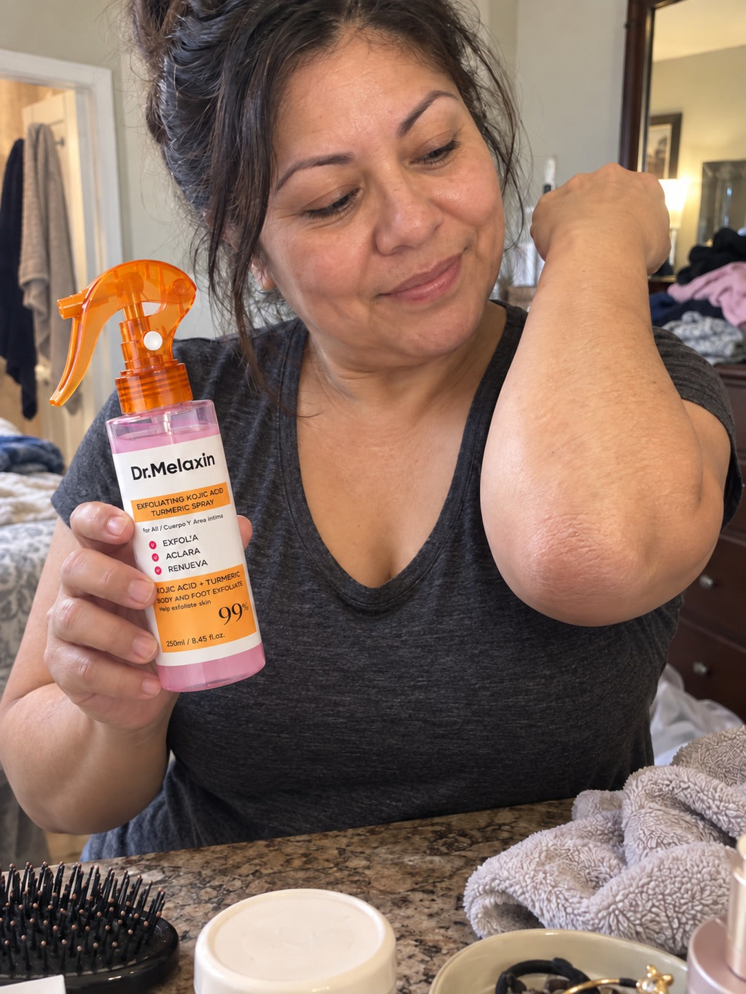 Customer caring for rough-feeling elbows with a spray exfoliant