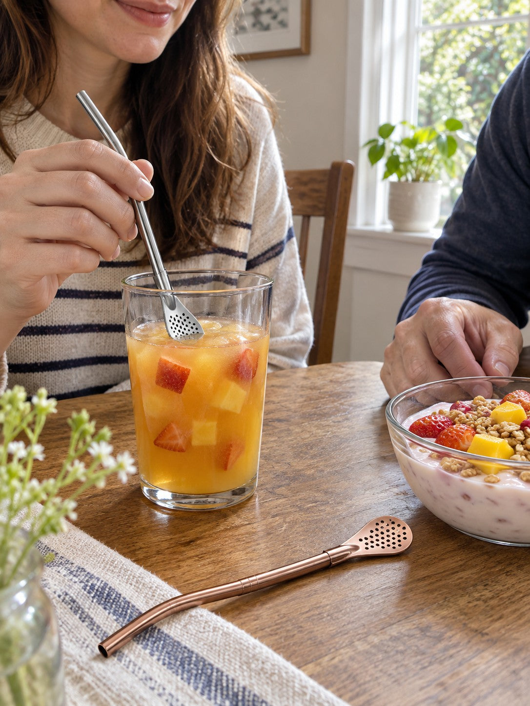 Two spoon straws used with fruit juice and a fruit yogurt bowl