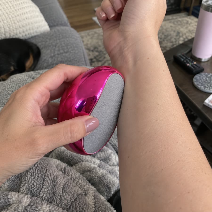 Pink crystal hair eraser used on an arm while sitting on a couch