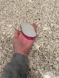 Pink crystal hair eraser held over a granite counter