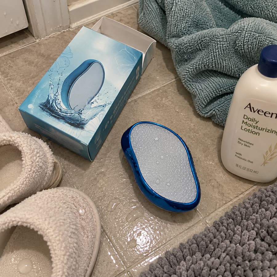 Blue crystal hair eraser and box on bathroom floor with towels and lotion