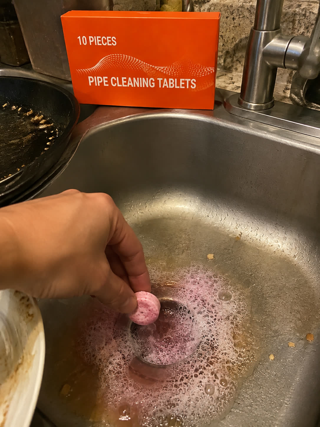 Customer photo using tablet in kitchen sink with food residue