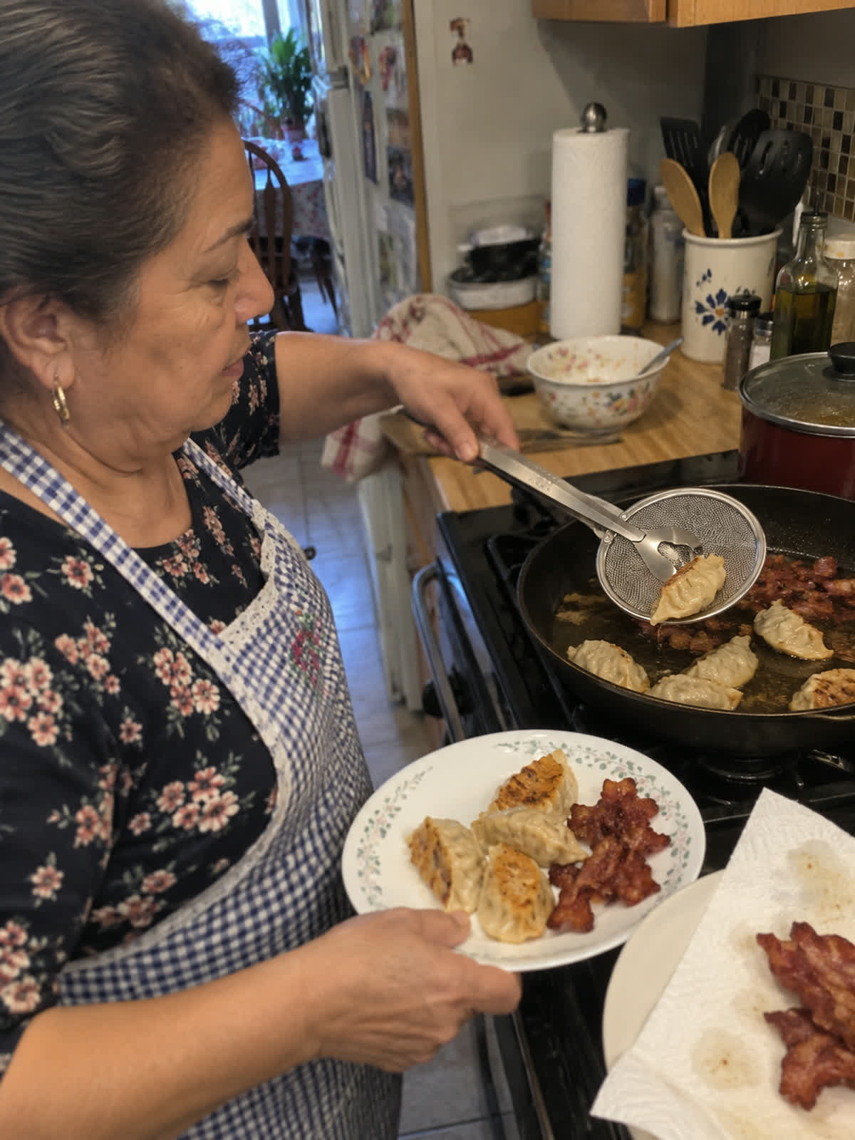 Customer using spider strainer tongs in a home kitchen