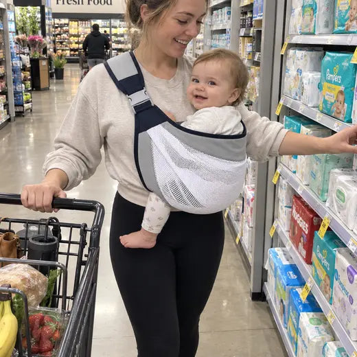 Mother wearing the baby sling carrier while shopping for diapers