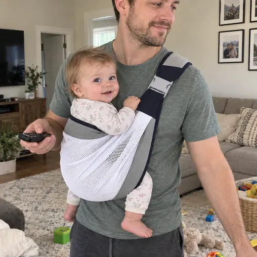 Father wearing the baby sling carrier in the living room