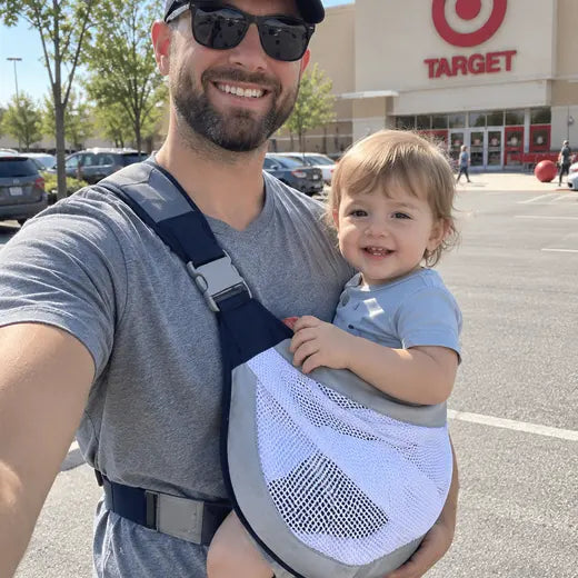 Father wearing the baby sling carrier outside a store