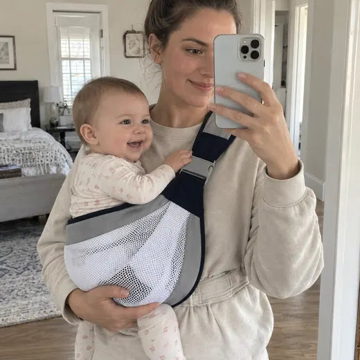 Mother taking a mirror selfie while wearing the mesh baby sling carrier