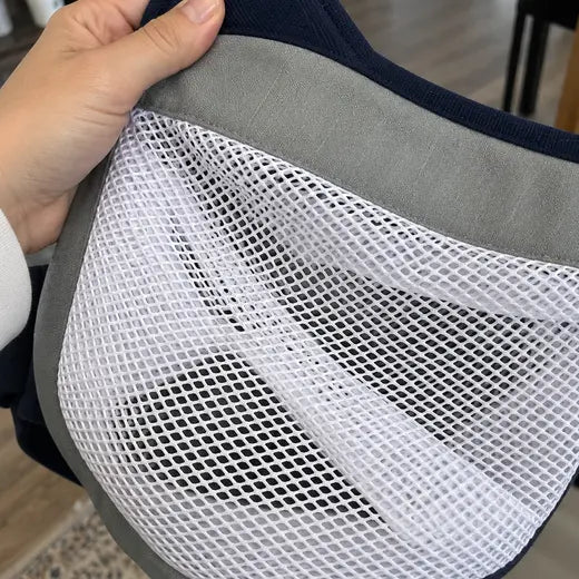 Close-up of the gray mesh baby sling carrier fabric and reinforced edge