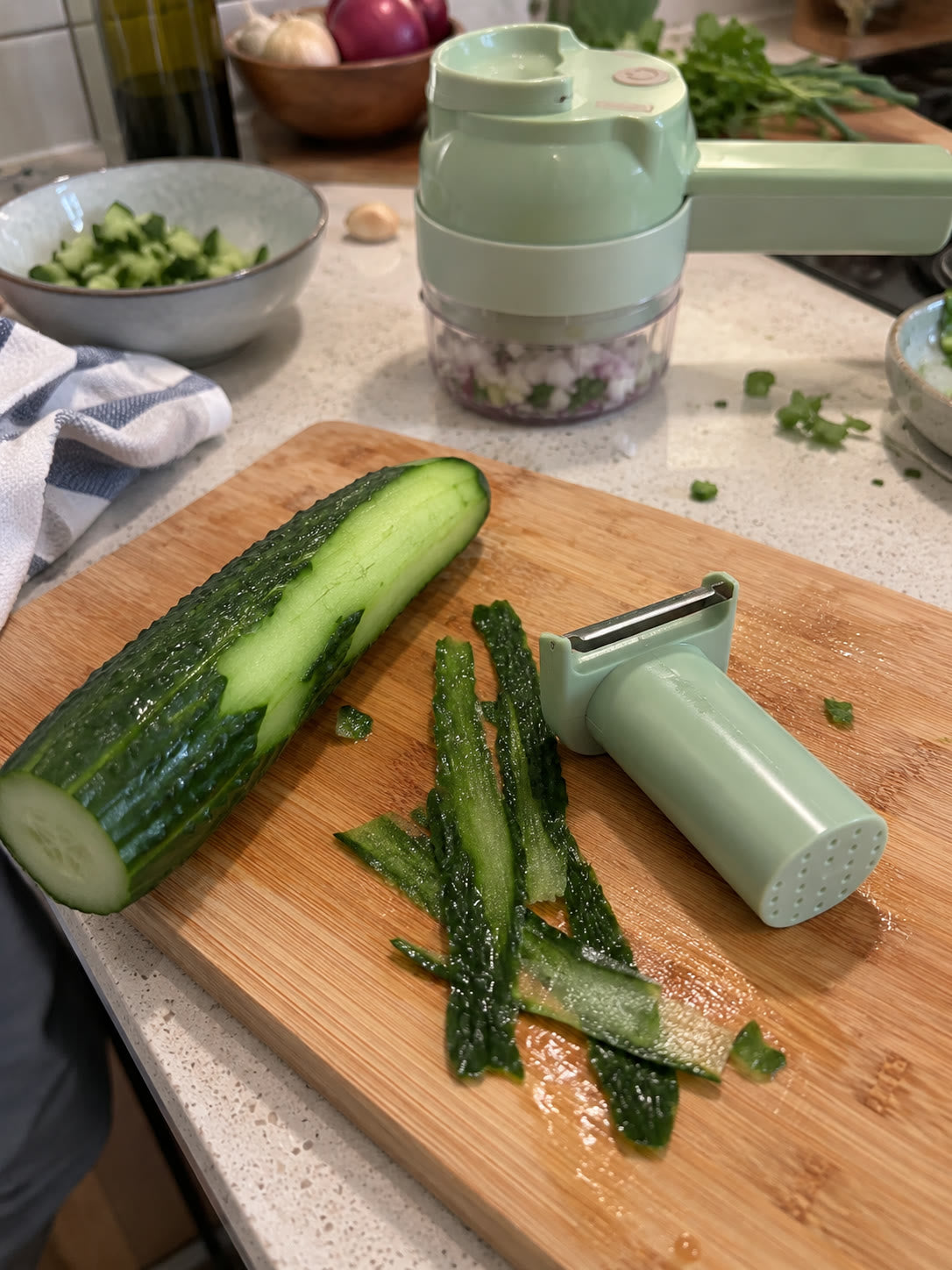 The included peeler beside a partially peeled cucumber