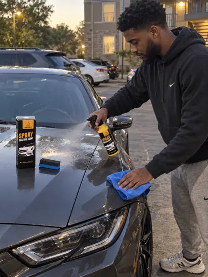 Customer spraying car coating spray on a dark car hood at dusk