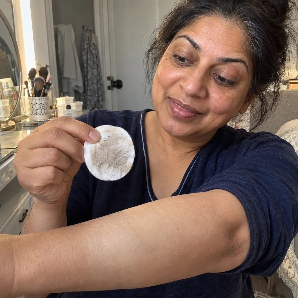 Customer caring for rough-feeling elbows with a spray exfoliant