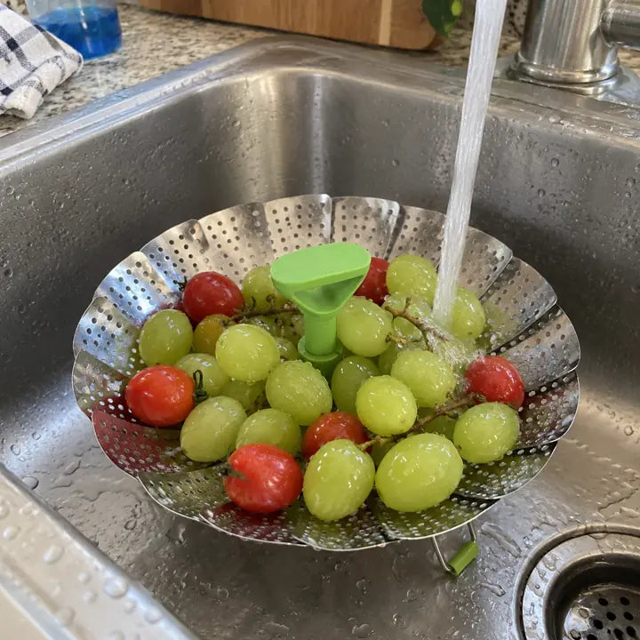 Customer rinsing grapes and tomatoes in steamer basket