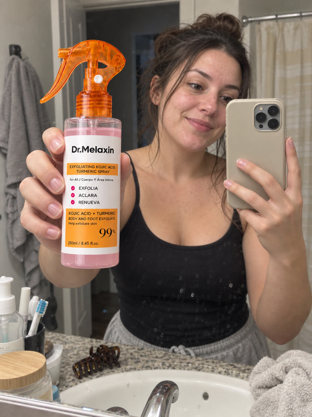 Customer holding a convenient body exfoliating spray bottle