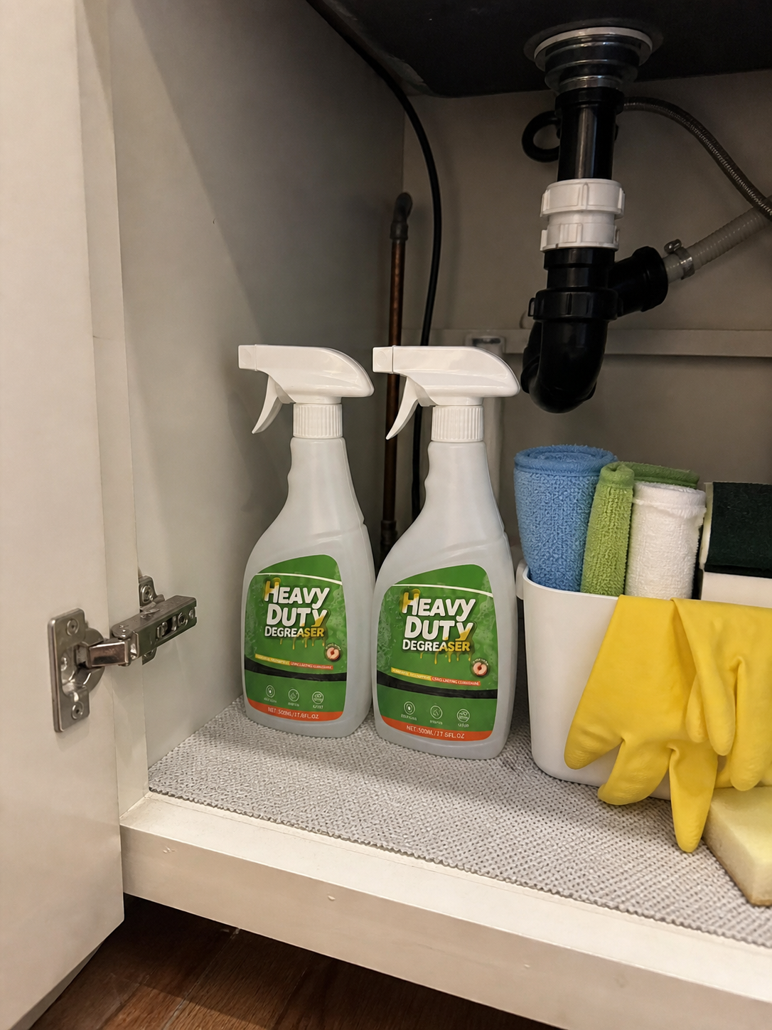 Customer photo showing two bottles with gloves and cleaning cloths under the sink