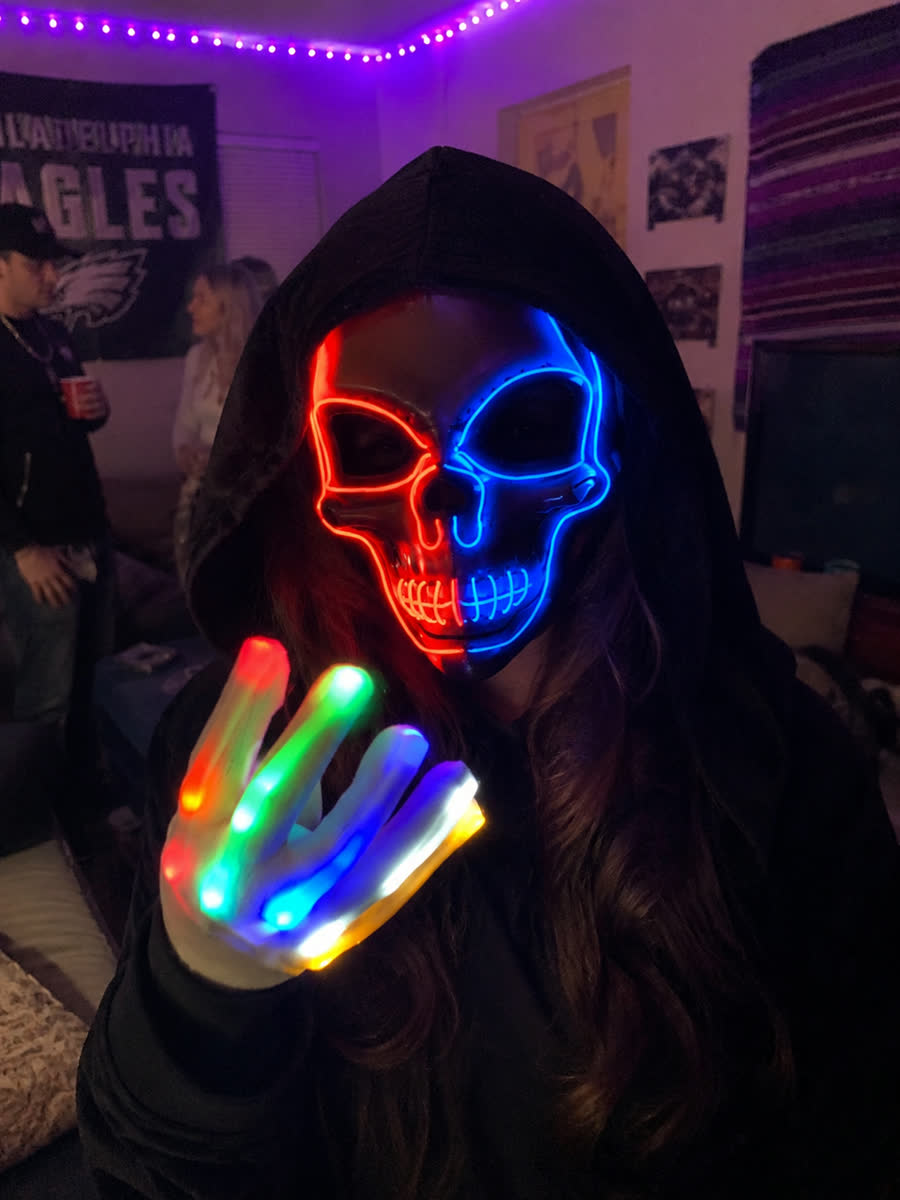 Customer wearing the LED glow skull mask with light-up gloves at a Halloween party