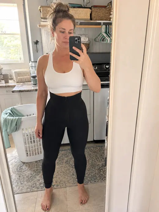 Woman wearing black leggings in a laundry room mirror selfie