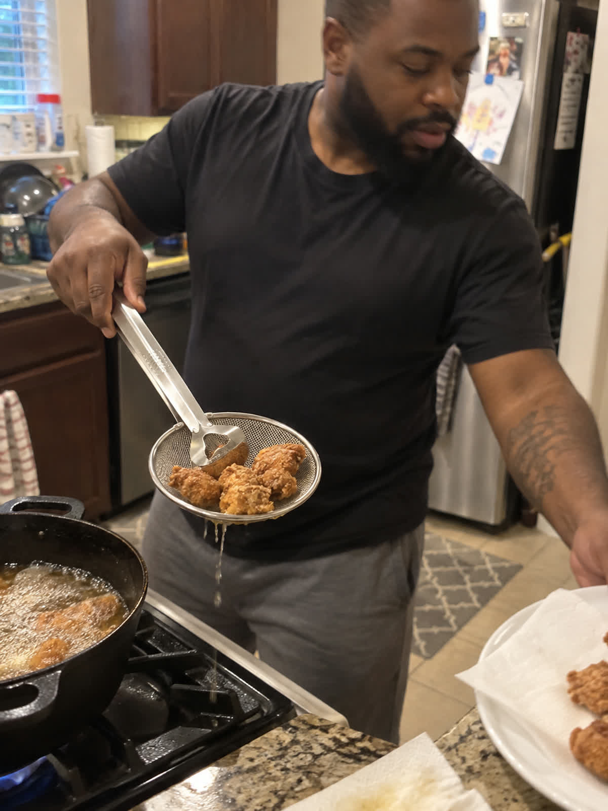 Customer using spider strainer tongs in a home kitchen